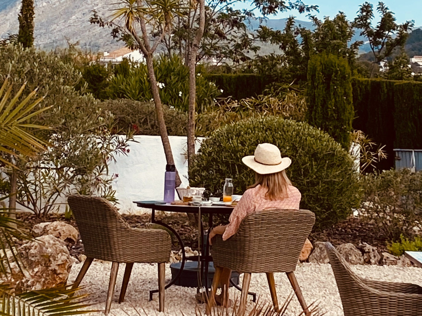 Guest working at an outdoor table under the trees with views over the valley