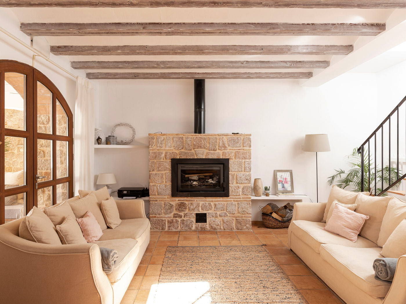 Lounge with a stone fireplace and deep sofas at Cuatre Finques